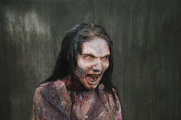 Xan angelovich, uma das zumbis da série de tv de the walking dead, grunhindo após ser devidamente maquiada.