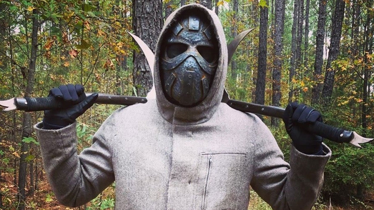 A pessoa da máscara de metal que acompanha Maggie, no 16º episódio da 10ª temporada de The Walking Dead.